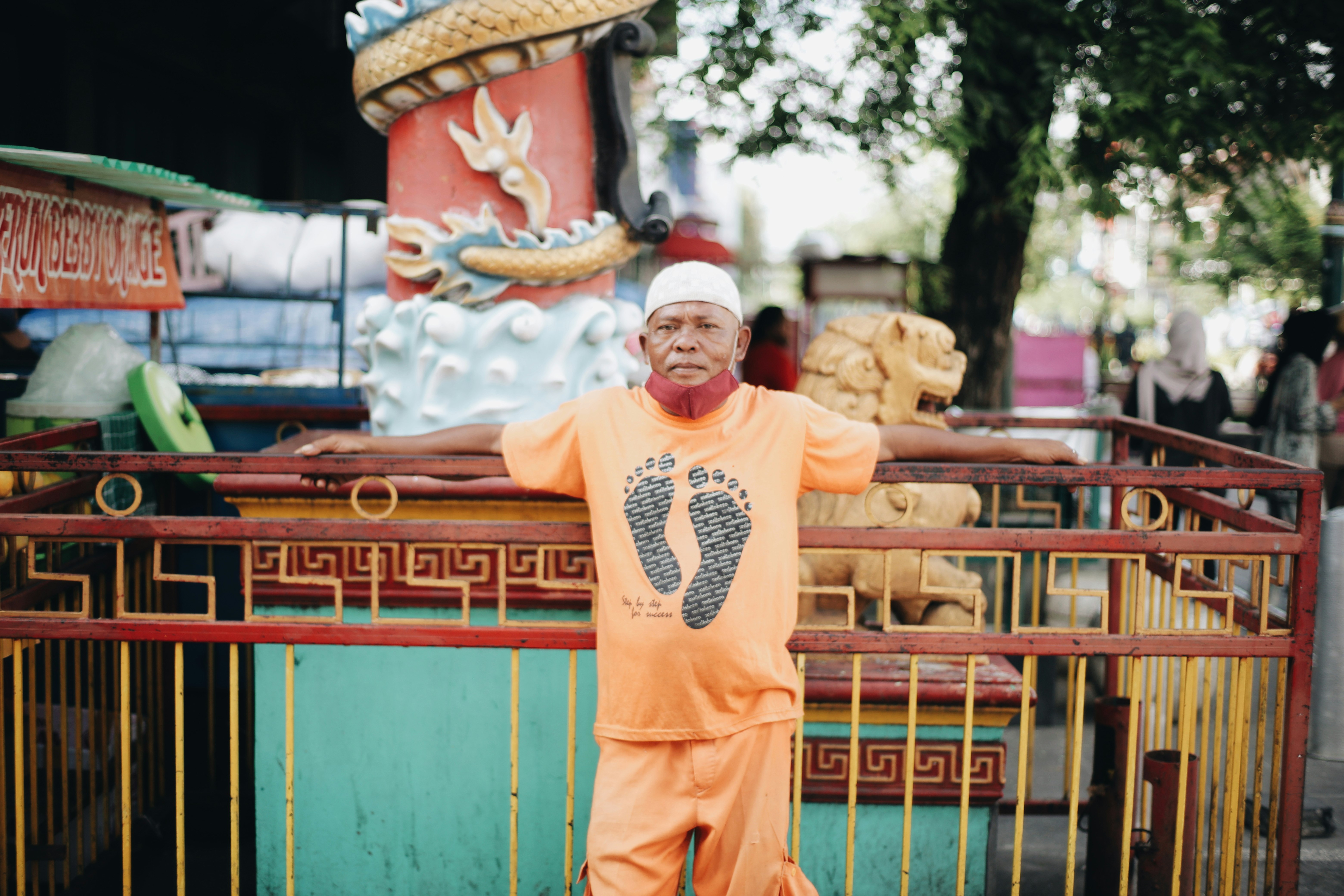 man in orange long sleeve shirt and pants standing on green and yellow wooden house during